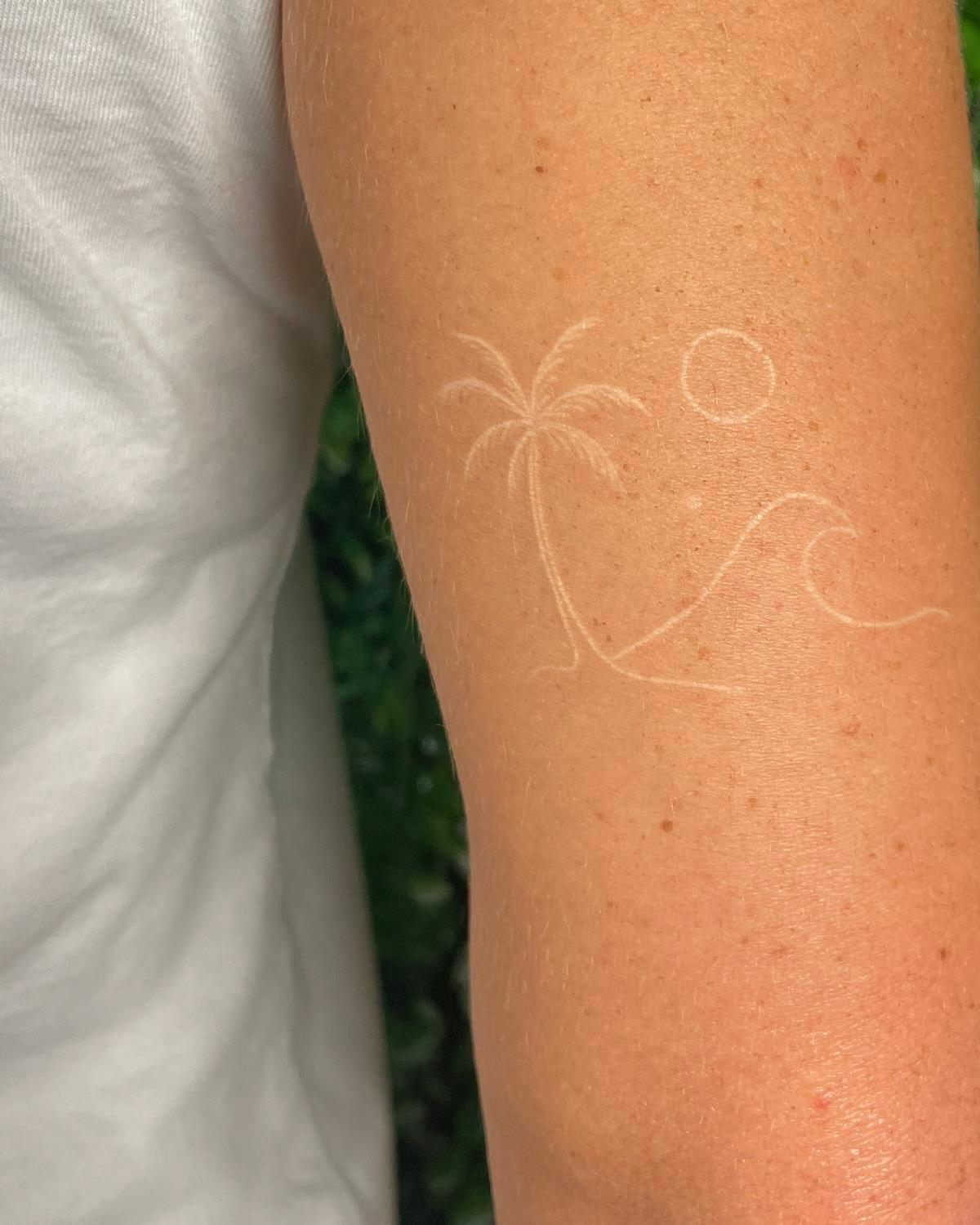 Weißes Tattoo mit Palme, Welle und Sonne